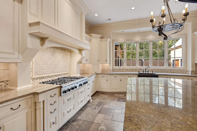 kitchen with stainless steel gas cooktop, ornamental molding, sink, light stone counters, and tasteful backsplash