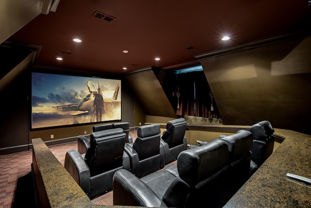 carpeted home theater room with ornamental molding and lofted ceiling