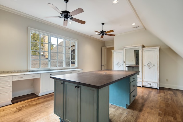 kitchen featuring ornamental molding, a center island, light wood-type flooring, white cabinetry, and ceiling fan