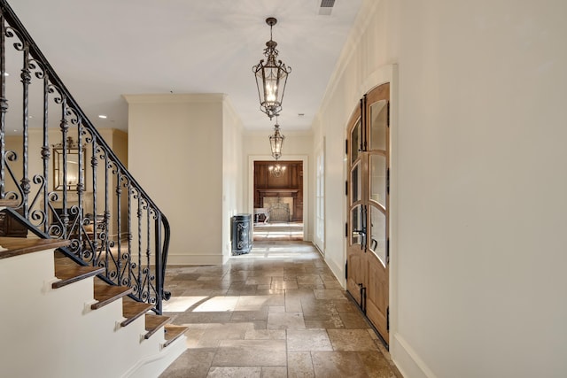 214 Mountain Brook Cv, Eads, TN 38028 - entrance foyer with stairway, stone tile floors, crown molding, an inviting chandelier, and baseboards