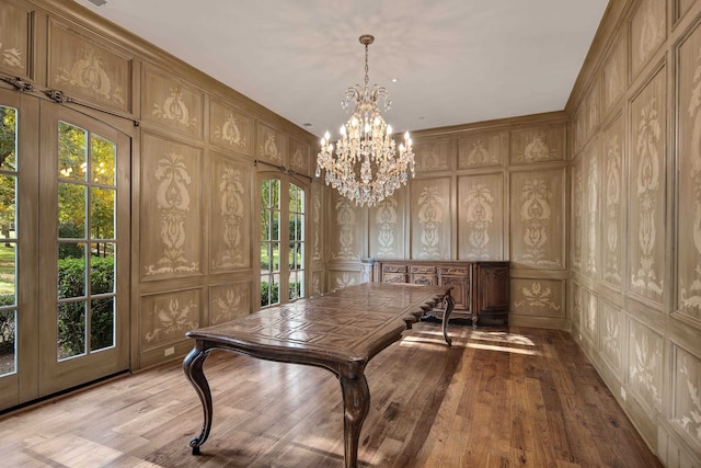 interior space with light hardwood / wood-style flooring, french doors, an inviting chandelier, and a wealth of natural light