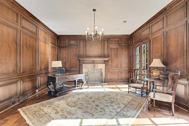 office area featuring wood walls, light hardwood / wood-style flooring, and an inviting chandelier