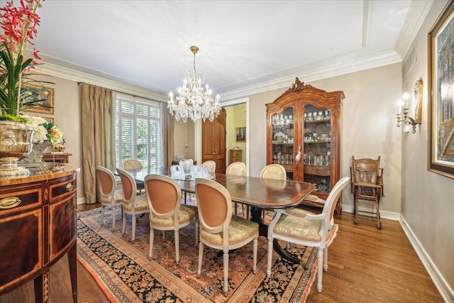 dining space with an inviting chandelier, crown molding, and light hardwood / wood-style floors