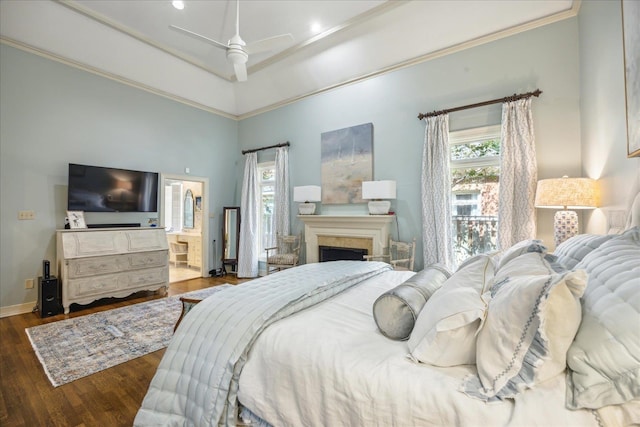 bedroom with dark wood-type flooring, ceiling fan, connected bathroom, and ornamental molding