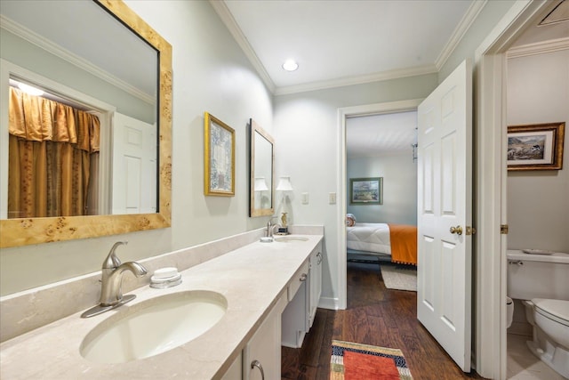 bathroom featuring toilet, hardwood / wood-style floors, vanity, and ornamental molding