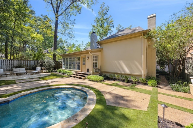 back of house with a patio, an outdoor living space, and a jacuzzi