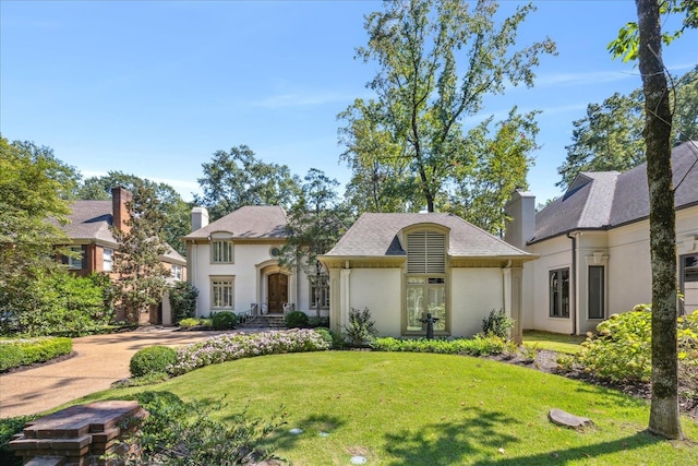 french country style house with a front lawn