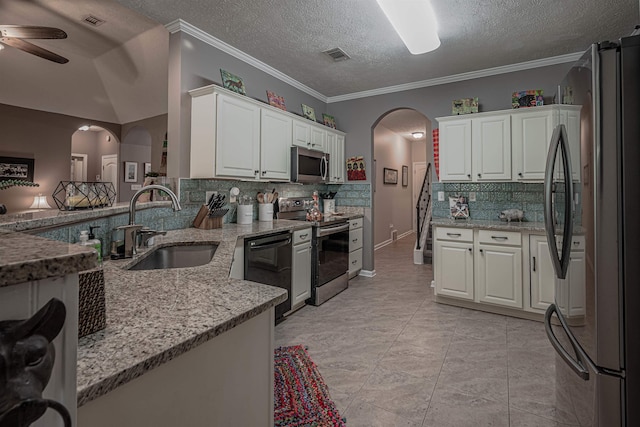 kitchen with kitchen peninsula, a textured ceiling, stainless steel appliances, sink, and white cabinetry