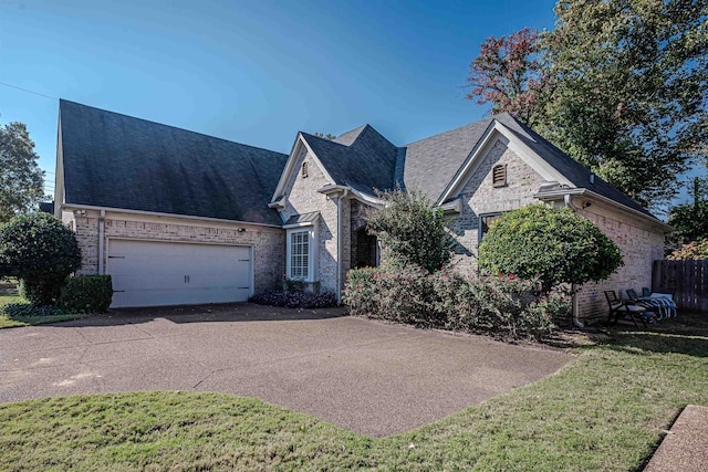 view of front of home with a garage and a front lawn