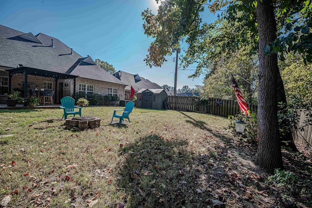 view of yard with an outdoor fire pit and a storage shed