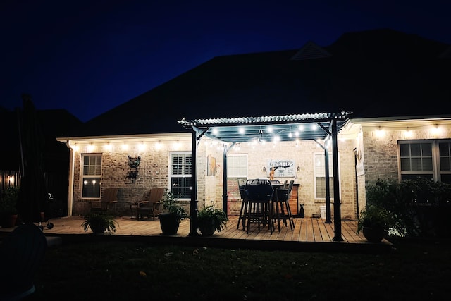 patio at night featuring a deck