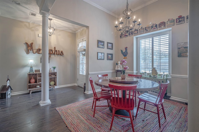 dining area with a notable chandelier, dark hardwood / wood-style flooring, ornate columns, and ornamental molding