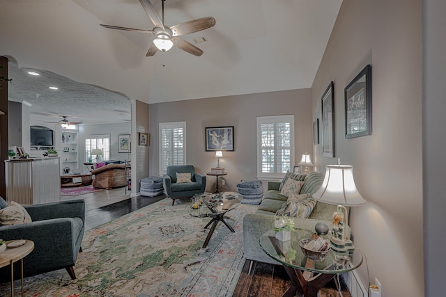 living room with wood-type flooring, a textured ceiling, vaulted ceiling, and plenty of natural light