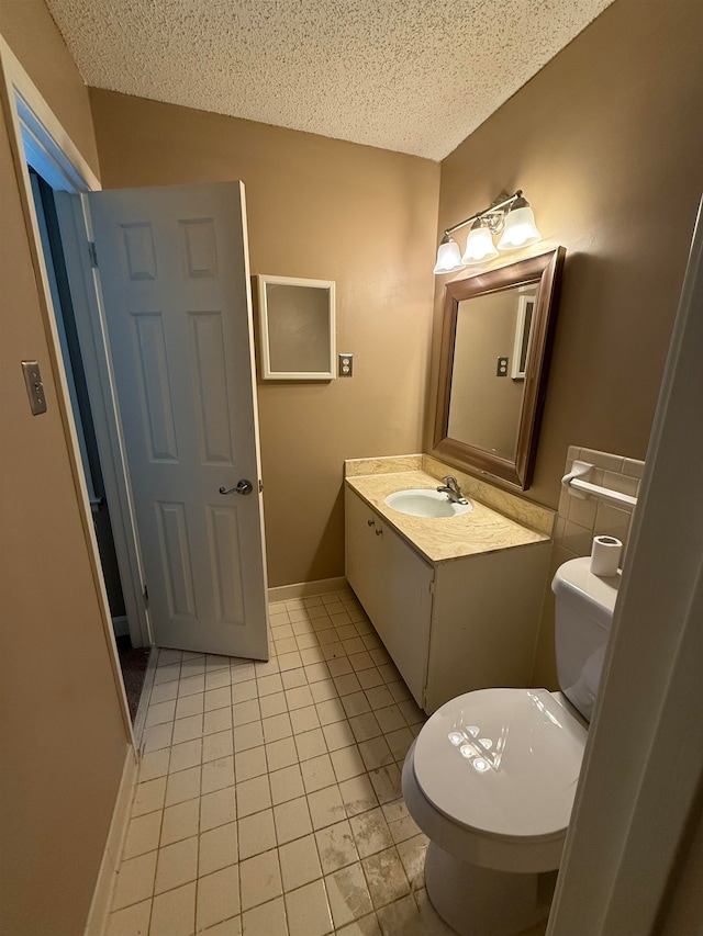 bathroom featuring vanity, a textured ceiling, toilet, and tile patterned flooring