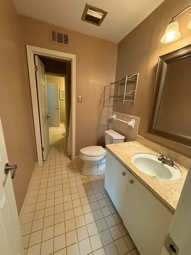 bathroom with vanity, toilet, and tile patterned flooring