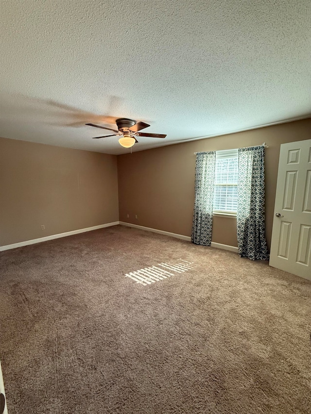 carpeted spare room featuring a textured ceiling and ceiling fan