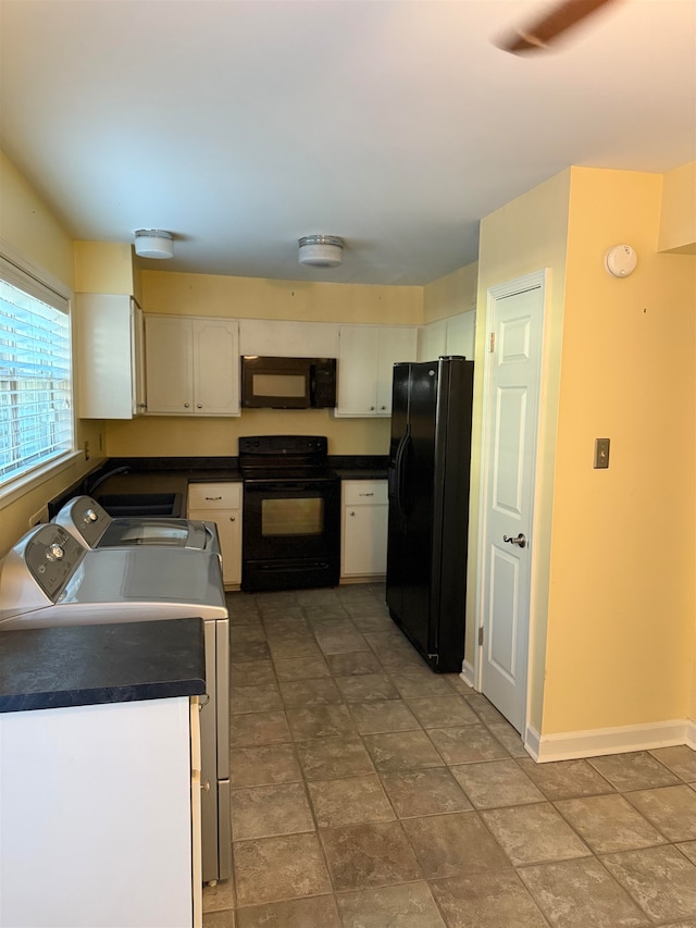 kitchen featuring independent washer and dryer, black appliances, and white cabinets