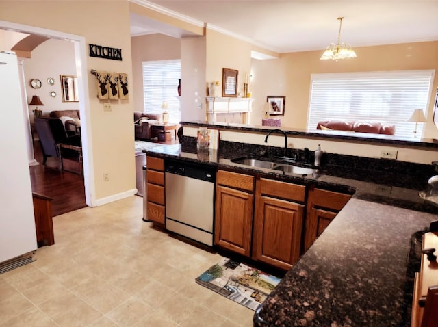 kitchen with an inviting chandelier, dark stone counters, dishwasher, pendant lighting, and sink