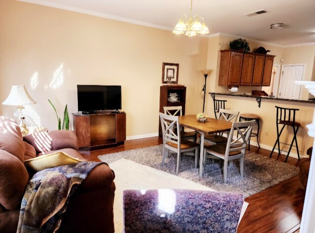 dining room featuring an inviting chandelier, crown molding, and light hardwood / wood-style floors