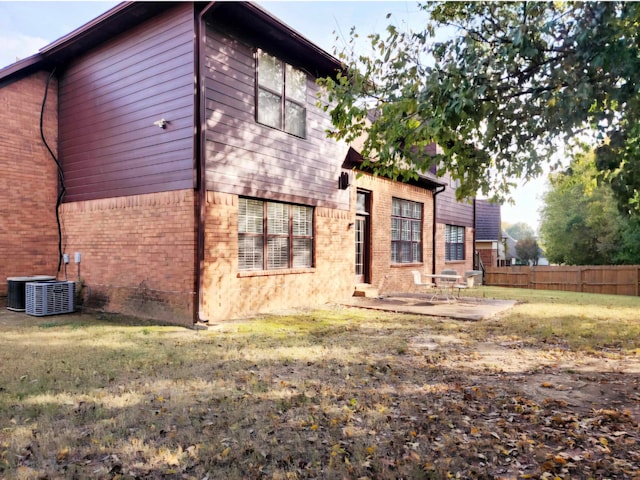 back of property with a patio area, a yard, and cooling unit