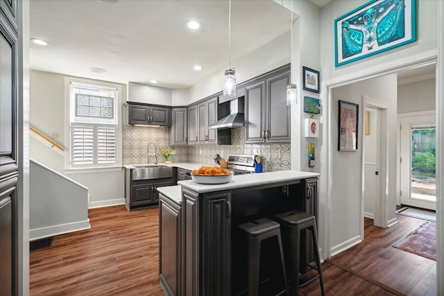 kitchen featuring wall chimney exhaust hood, sink, plenty of natural light, and gray cabinets