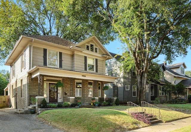 craftsman inspired home featuring covered porch and a front yard