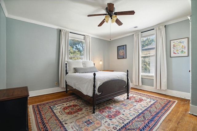 bedroom with hardwood / wood-style floors, crown molding, and ceiling fan