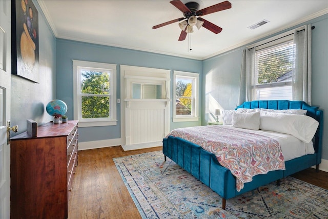 bedroom with ceiling fan, ornamental molding, and dark hardwood / wood-style floors