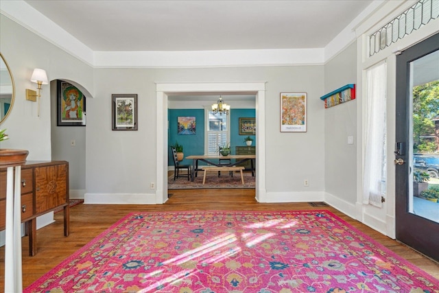 foyer entrance with an inviting chandelier and wood-type flooring