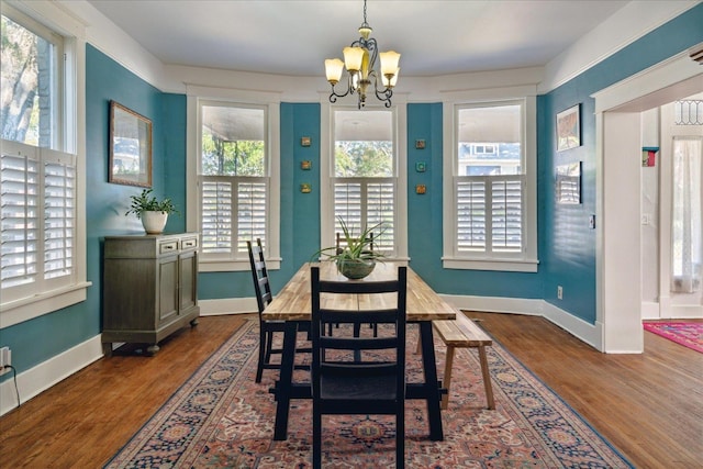 dining room with an inviting chandelier, dark wood-type flooring, and plenty of natural light