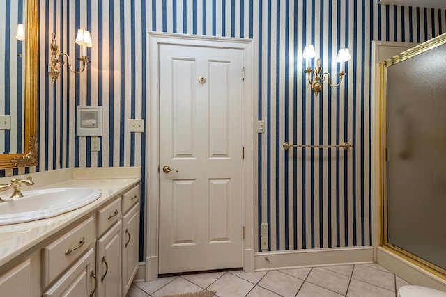 bathroom with a shower with door, vanity, and tile patterned floors