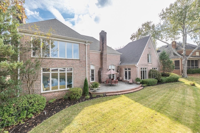 rear view of house with a yard and a patio