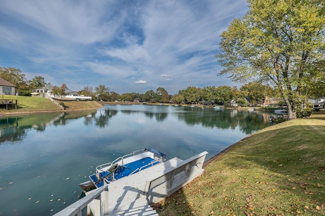 view of dock with a water view and a lawn