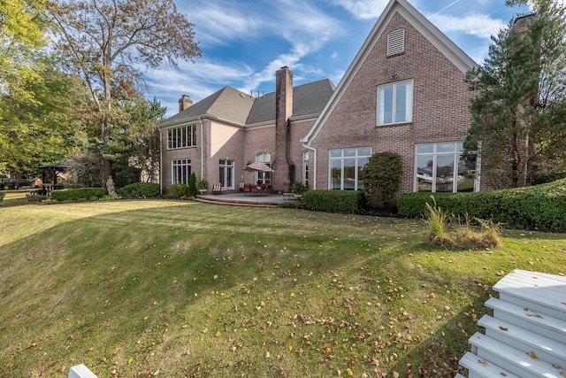 back of house featuring a patio area and a lawn