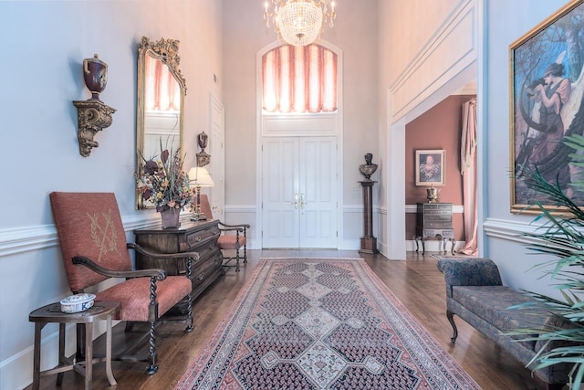 foyer entrance with a chandelier, dark hardwood / wood-style floors, and a high ceiling