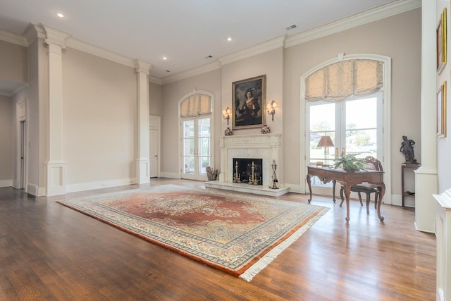 living room featuring ornate columns, crown molding, and wood-type flooring