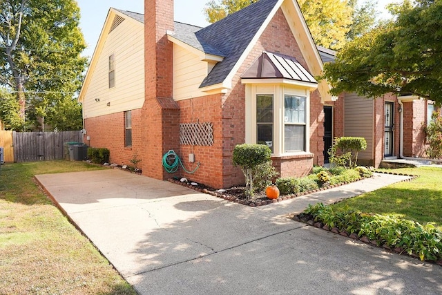 view of side of property with central AC and a yard