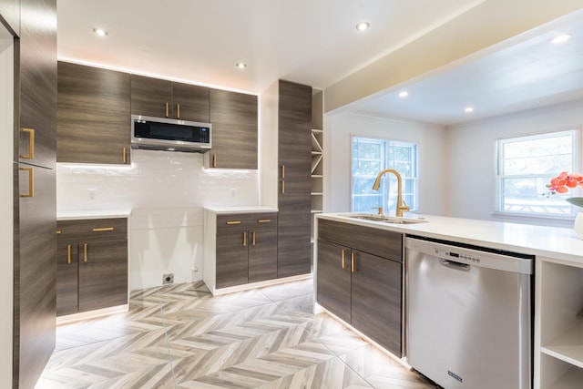 kitchen with a healthy amount of sunlight, stainless steel appliances, dark brown cabinetry, and sink