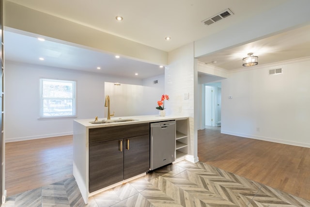 kitchen with crown molding, dark brown cabinets, sink, and stainless steel dishwasher