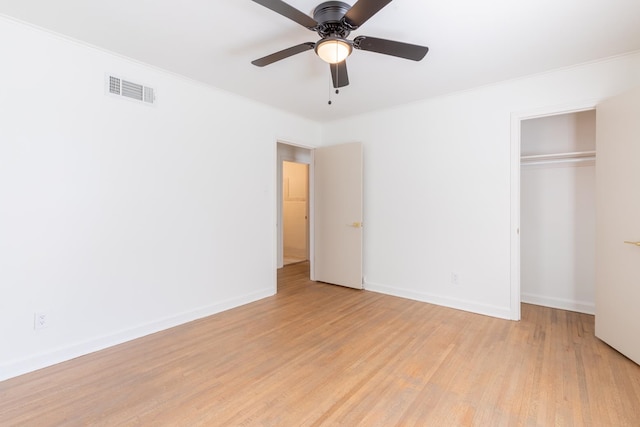 unfurnished bedroom featuring light hardwood / wood-style floors, crown molding, a closet, and ceiling fan