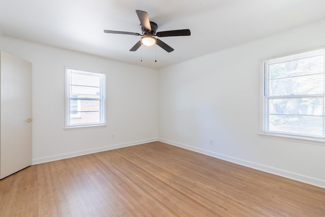 spare room featuring a wealth of natural light, light hardwood / wood-style flooring, and ceiling fan