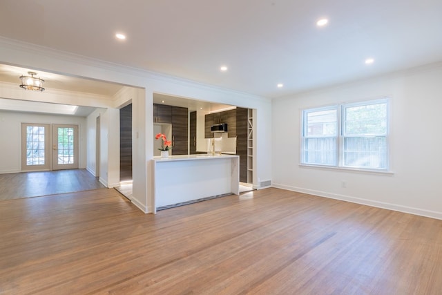 interior space with french doors, light hardwood / wood-style floors, and crown molding