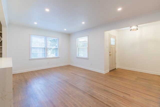 spare room featuring crown molding and light hardwood / wood-style floors