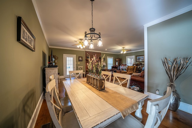 dining space with ornamental molding, wood-type flooring, and ceiling fan with notable chandelier