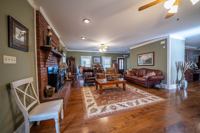 living room featuring ornamental molding, dark wood-type flooring, a fireplace, and ceiling fan