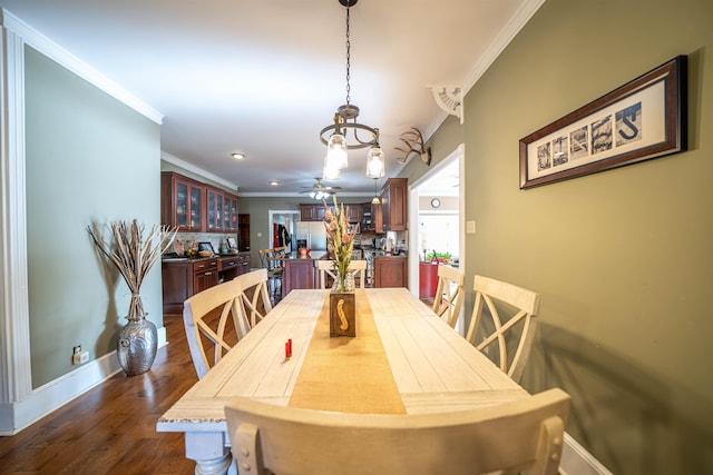 dining room with crown molding, dark hardwood / wood-style flooring, and ceiling fan