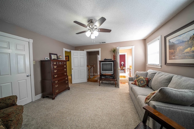 living room featuring ceiling fan, a textured ceiling, and carpet floors