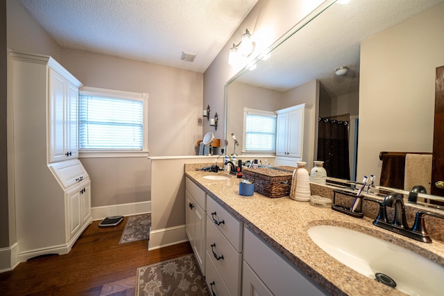 bathroom featuring vanity, a textured ceiling, and hardwood / wood-style floors