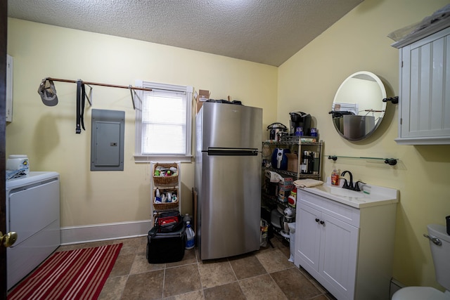 laundry room with washer / dryer, a textured ceiling, electric panel, and sink