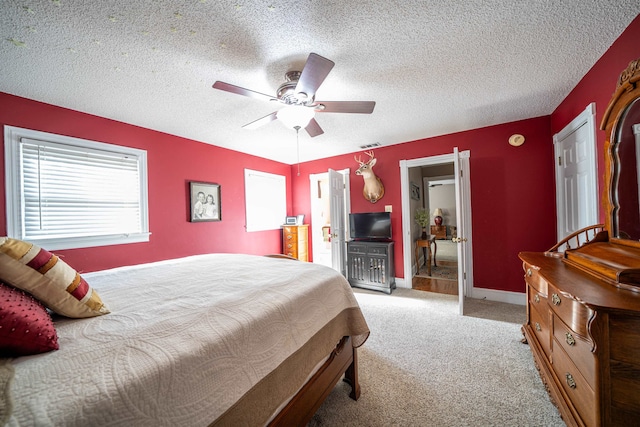 carpeted bedroom featuring a textured ceiling and ceiling fan